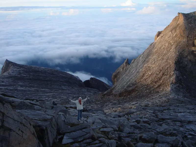 Les bras ouverts sur le granit, au-dessus des nuages