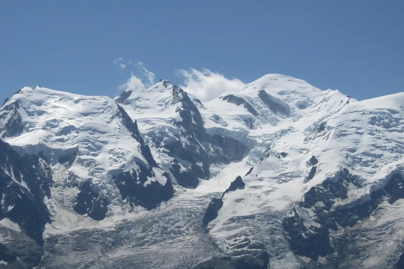 Le dôme enneigé du massif du Mont Blanc sous un ciel bleu.