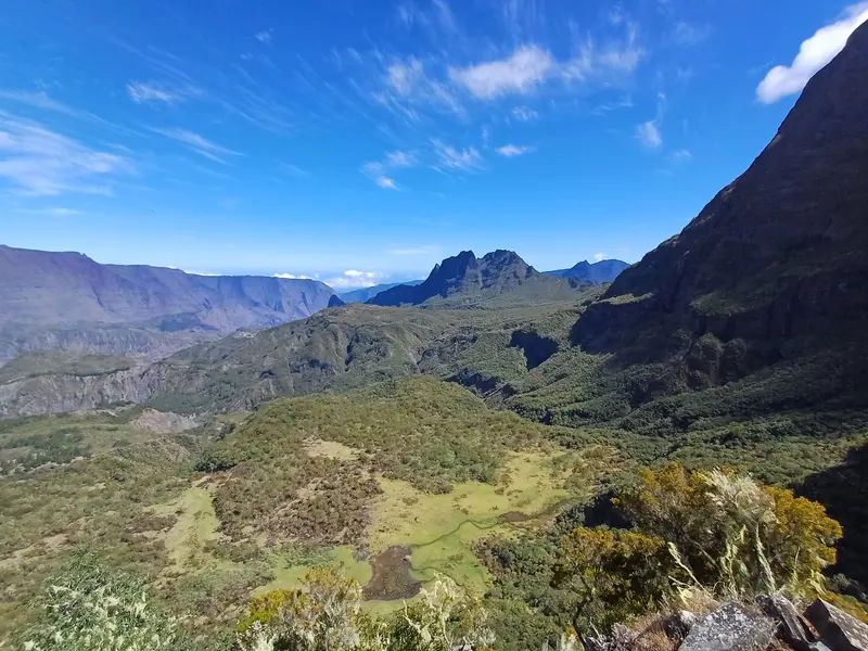 Une prairie verte au pied des pitons